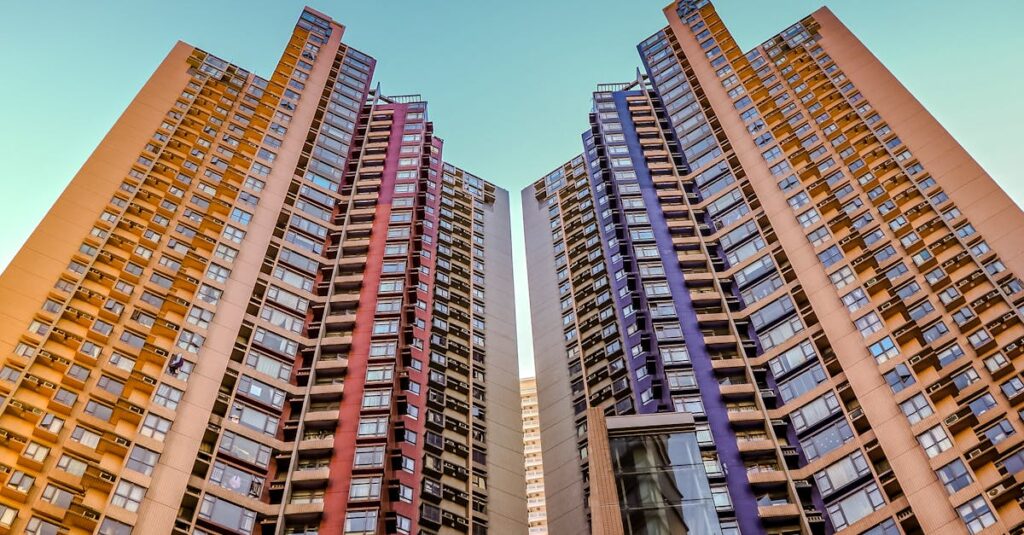 Tall, colorful skyscrapers reaching into the blue sky in Hong Kong, showcasing modern architecture.